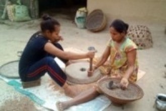 जाँतोमा दाल पिस्दै महिला